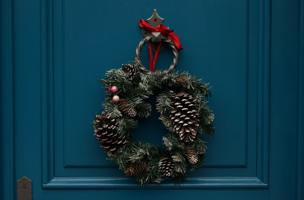 Adorno navideño colocado sobre una puerta azul
